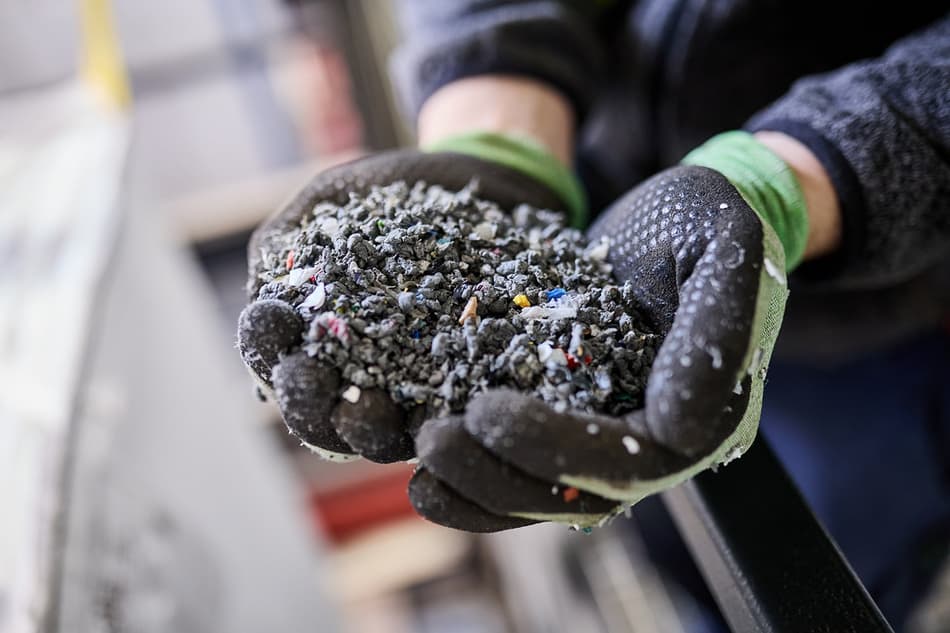 close up of gloved hands holding plastic granulate 