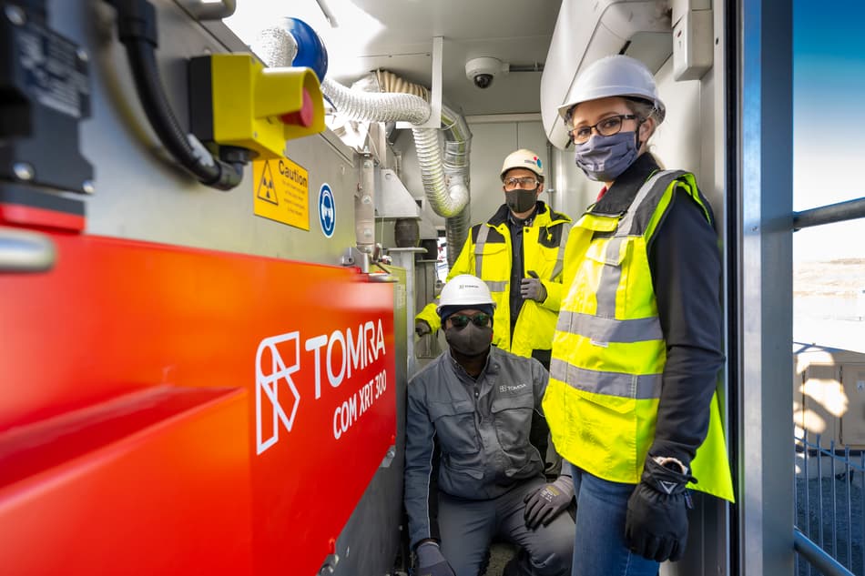 Three people standing next to Tomra COM XRT 300