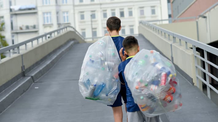 Boys carrying bags  with returnable bottles