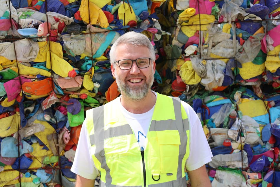 Alexander Verlo standing in front of plastic waste