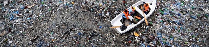 Image of boats moving through plastic pollution