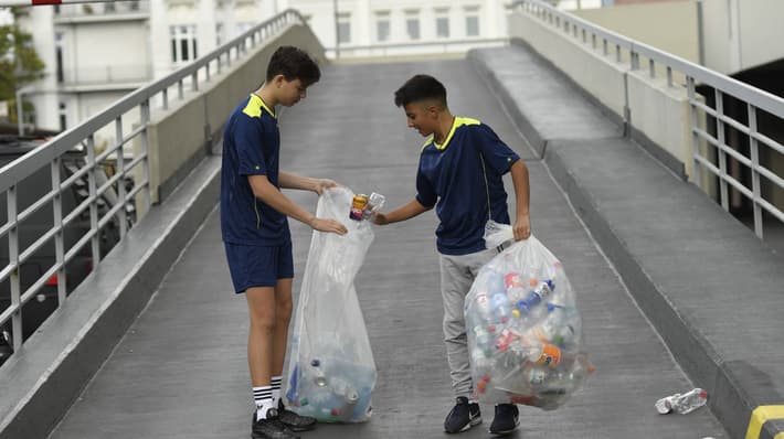 Boys on street with bags of recycling