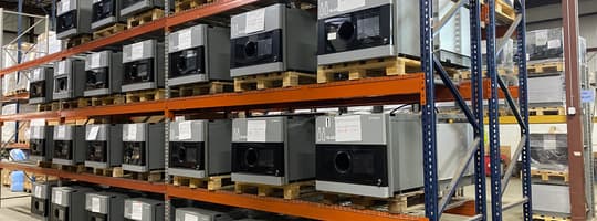 Refurbished TOMRA technology stacked on shelves in a warehouse