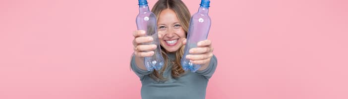 Smille woman with recyclable bottles 