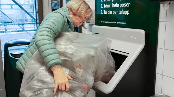 Customer in store using Tomra R2 reverse vending machine