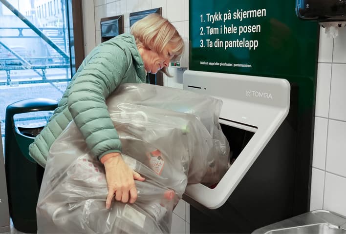 Customer in store using Tomra R2 reverse vending machine