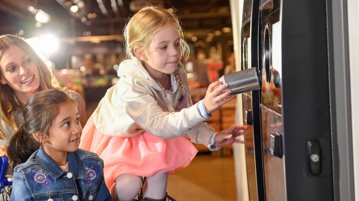 Image of family returning cans to reverse vending machine