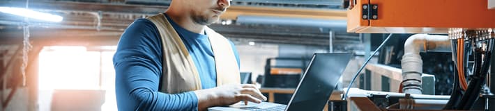 TOMRA Feedstock employee working with laptop 