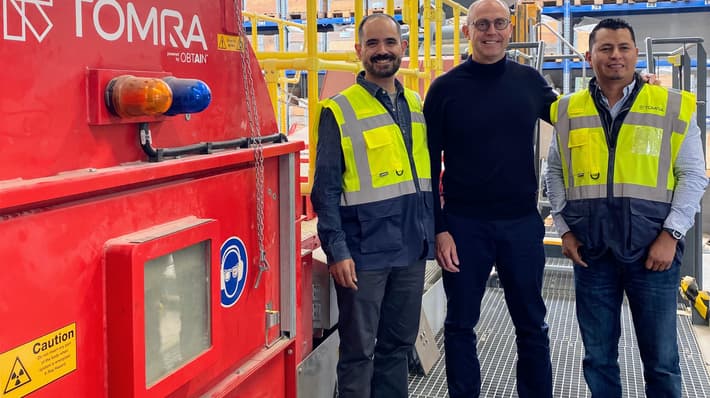Men standing next to TOMRA Mining Machine