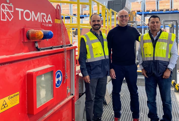 Men standing next to TOMRA Mining Machine