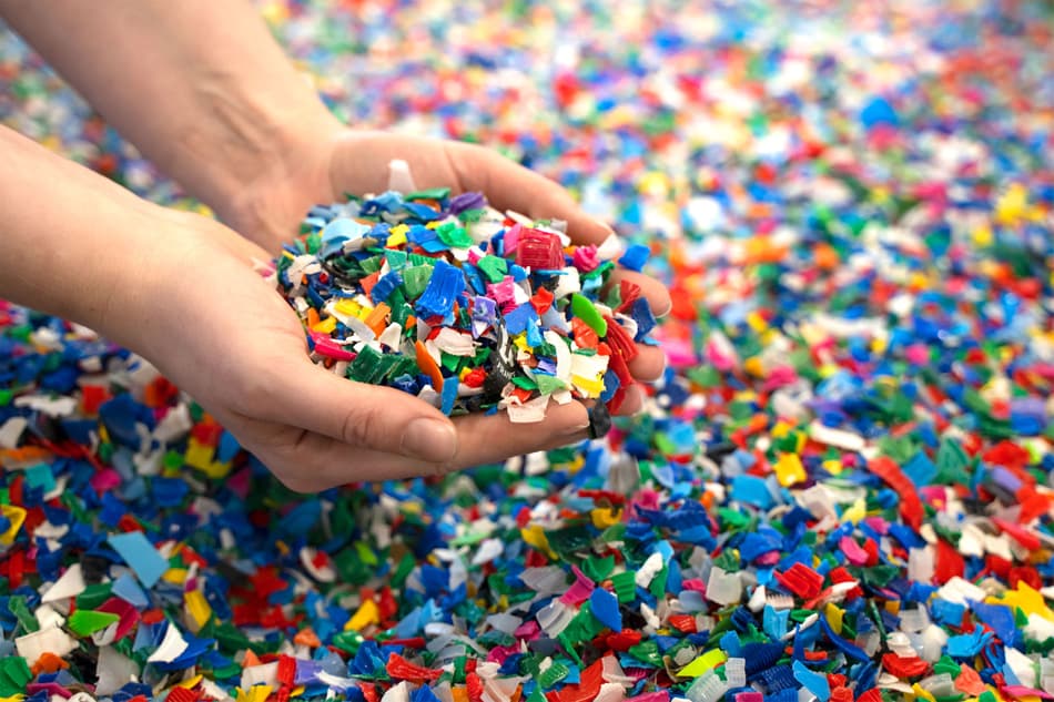 Hält bunte Plastikteile in der Hand