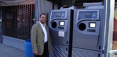 Man standing next to reverse vending machines 