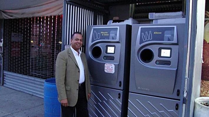 Man standing next to reverse vending machines 