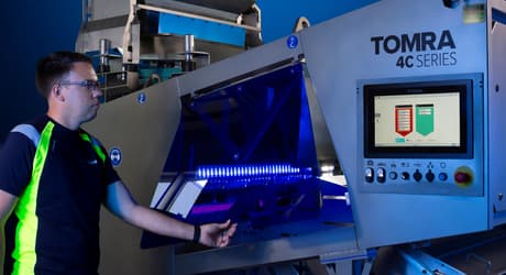 A man lifts the folding door on the TOMRA 4C optical sorting machine
