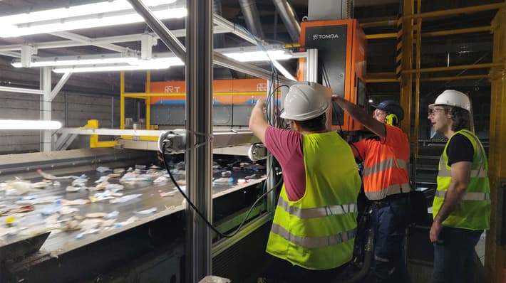 Men working on TOMRA AI Waste sorting machine