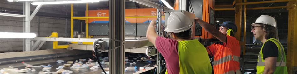 Men working on TOMRA AI waste sorting machine