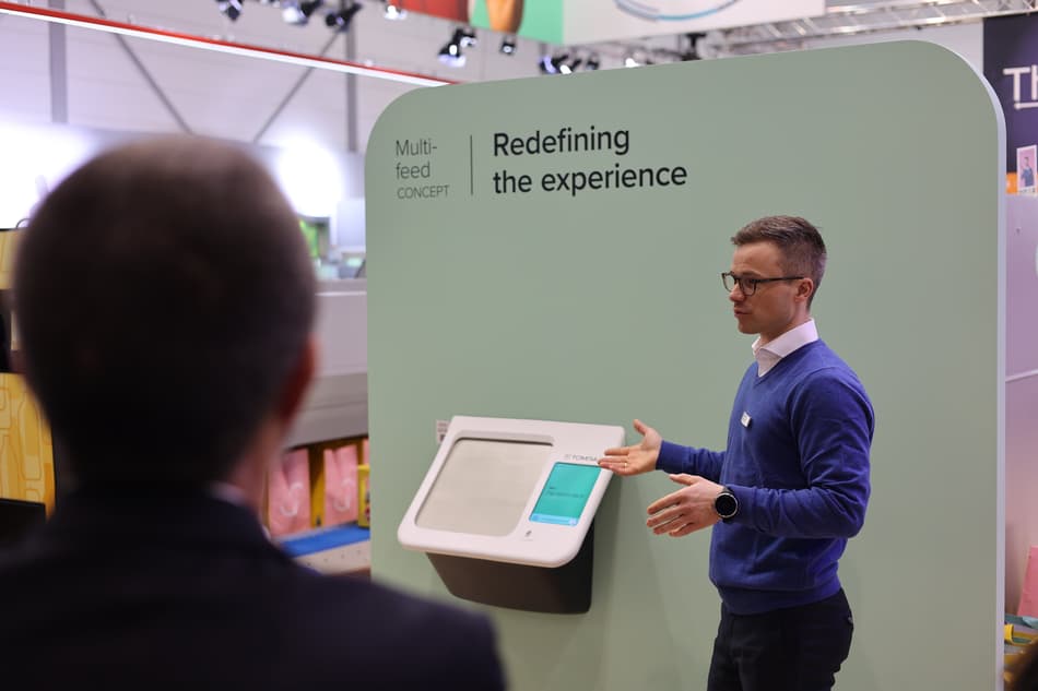 A man presenting the TOMRA multi-feed concept reverse vending machine at EuroShop