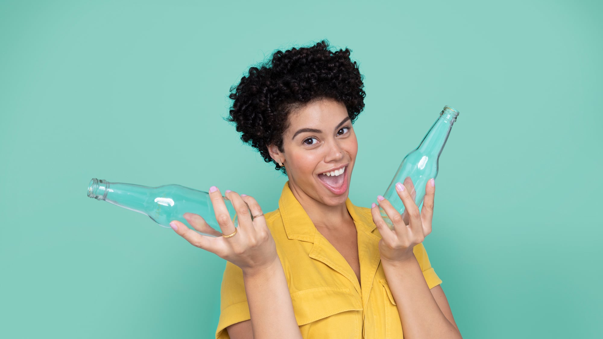 Smiling woman holding up two glass bottles 