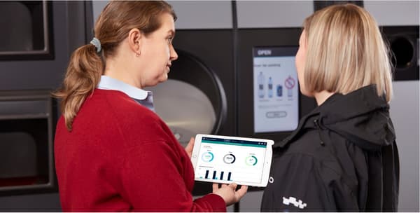 forhandler og TOMRA-medarbejder, der kigger på en iPad