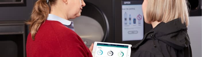 egy kiskereskedő és a tomra alkalmazottja egy iPad-et néz