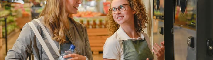 Retailer talking to woman in front a TOMRA T9 MUP
