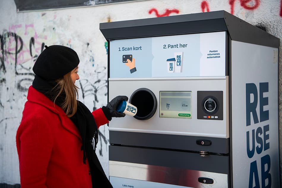 Woman in Aarhus returning a coffee cup at a REUSEABLE machine