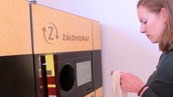 Woman returning bottles at TOMRA reverse vending machine in Slovakia