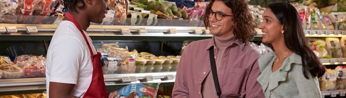 Store employee speaking with two customers