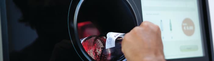 User infeed bottle into TOMRA T9 reverse vending machine