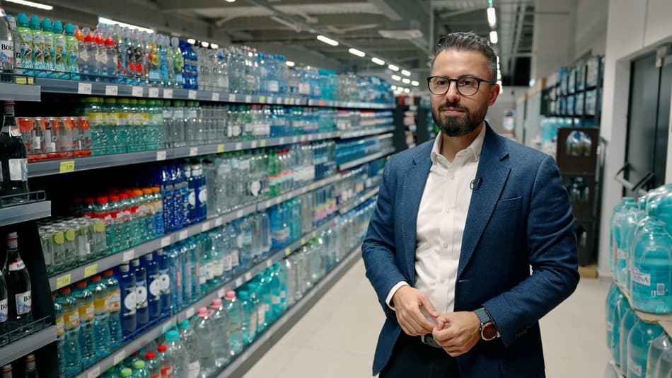 Man in front of shelf of bottles