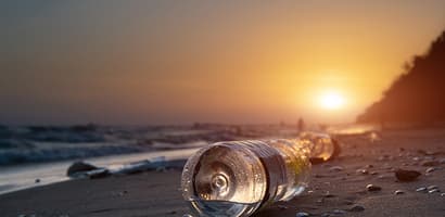 plastic bottles washed up on beach with setting sun