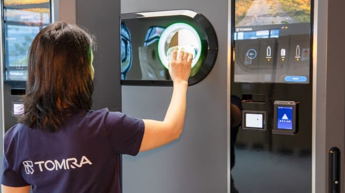 TOMRA employee with Singapore reverse vending machine