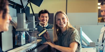 TOMRA employees next to Reverse Vending machine