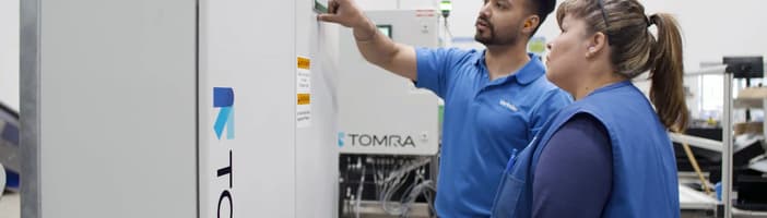 TOMRA personnel looking at a Expert Line screen