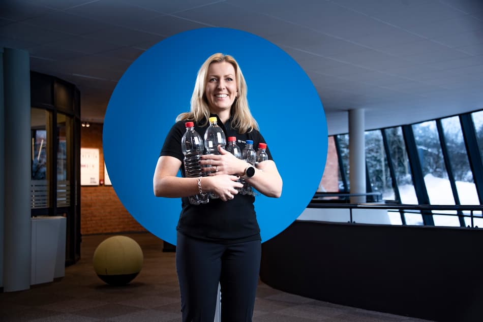 TOMRA President and CEO Tove Andersen holding empty plastic bottles