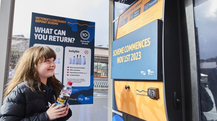 Girl in front of reverse vending machine
