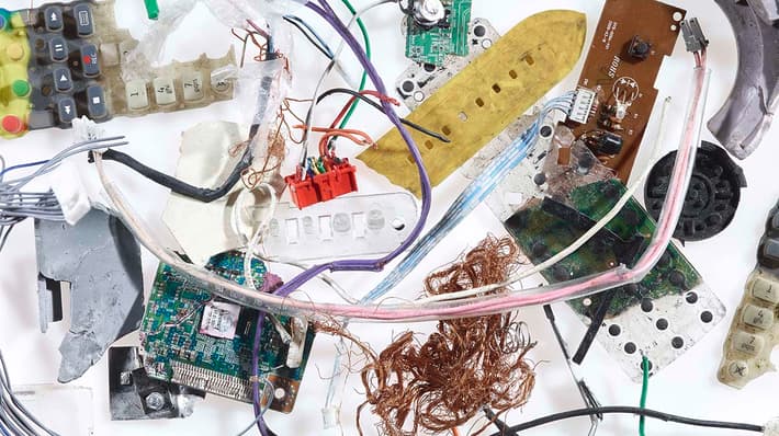 Diverse bits of electronic waste material against a white background