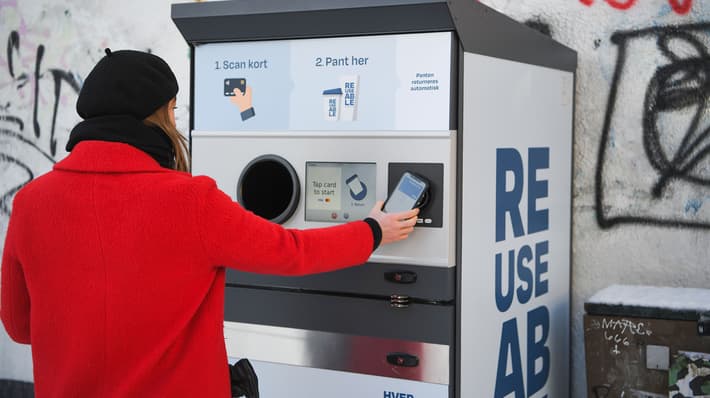 Consumer returning a reusable cup at a TOMRA collection point in Aarhus Denmark