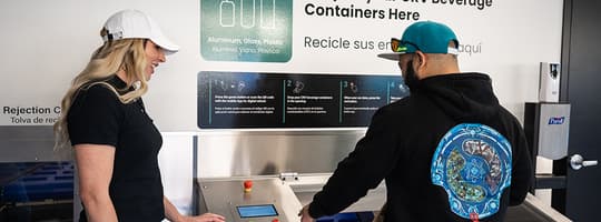 Man and woman using TOMRA Expert Line Reverse Vending Machine